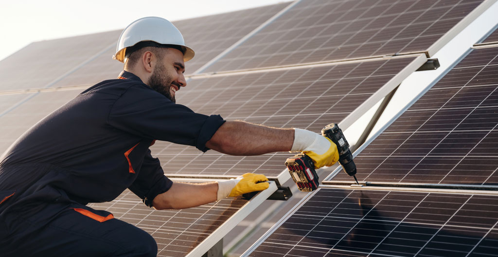 Technicien vérifie l'inclinaison d'une toiture photovoltaïque avec outil de mesure